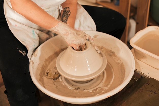 Free photo potter hands works with clay on pottery wheel