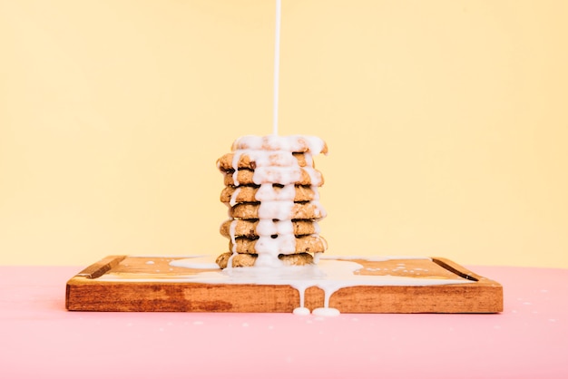 Free Photo pouring milk on cookies stack on wooden board