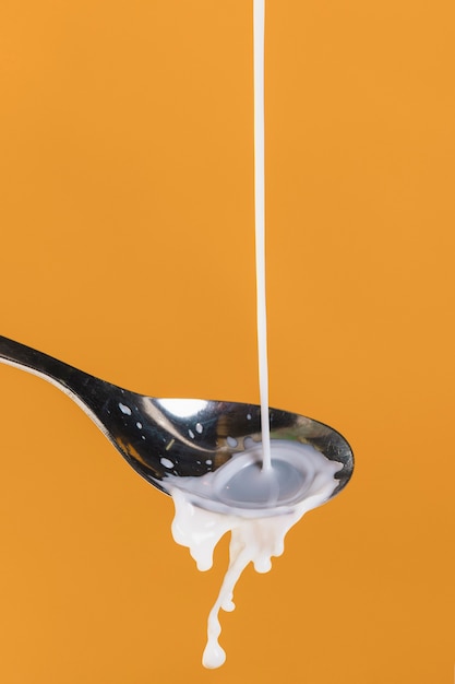 Free photo pouring milk in spoon process view