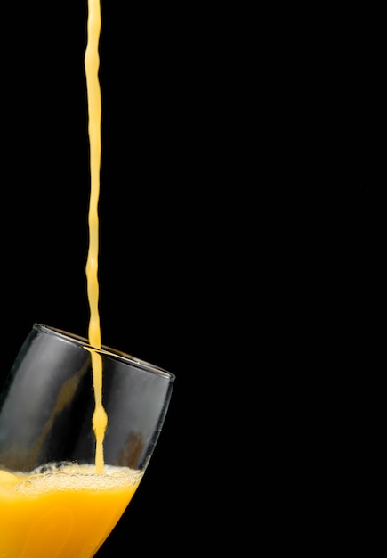 Free photo pouring orange juice into glass