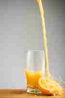 Free photo pouring orange juice into glass