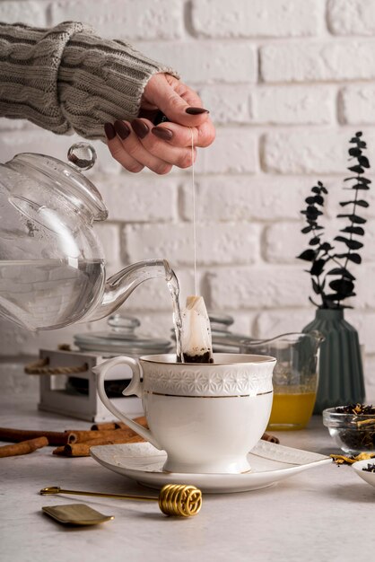 Pouring tea herbs in cup