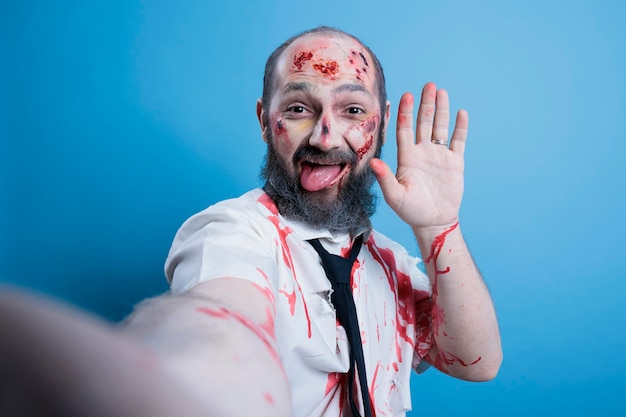 Free photo pov of man dressed as zombie for halloween taking selfies doing silly faces