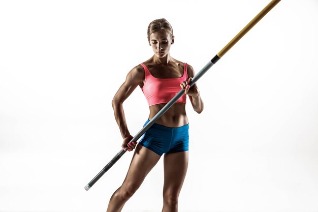 Power and beauty and purity. Professional female pole vaulter training on white wall. Fit and slim female model practicing. Concept of sport,