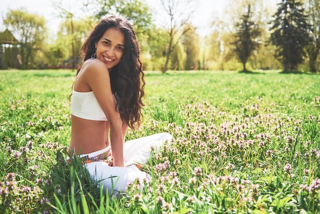 Practicing yoga of a beautiful girl in the morning on herbs under the sun's words.