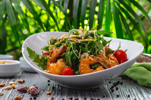 Prawns salad tomato arugula peanuts sauce side view