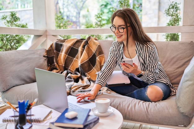 Preety student girl learning at home with laptop and mobile phone.