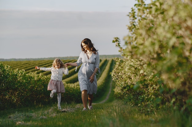 Pregnant mother with her daughter in a field