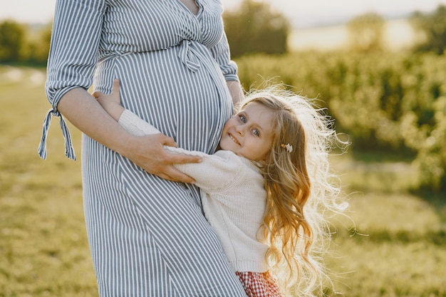 Pregnant mother with her daughter in a field