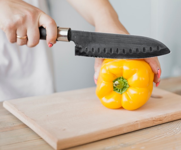 Free Photo pregnant woman cutting a yellow pepper