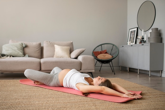 Pregnant woman doing yoga at home