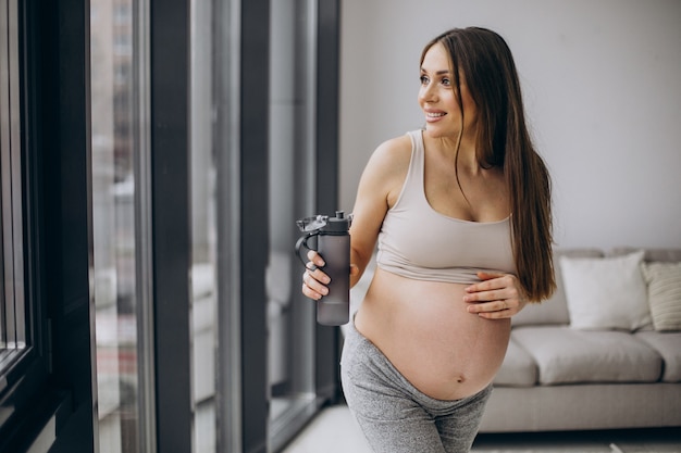 Pregnant woman having rest after exercising at home