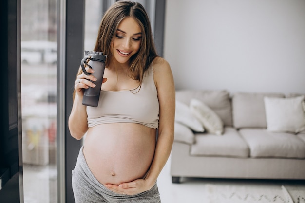 Pregnant woman having rest after exercising at home