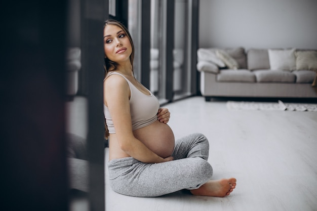 Free photo pregnant woman having rest after exercising at home