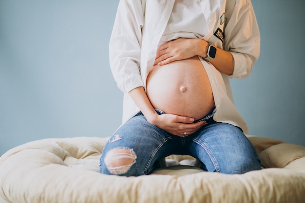 Free photo pregnant woman holding her belly