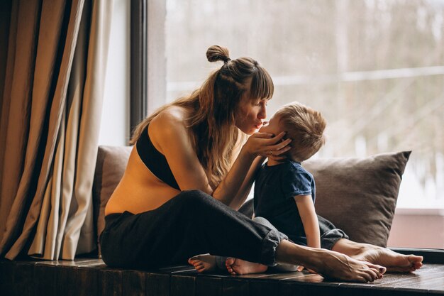 Pregnant woman with son sitting by the window