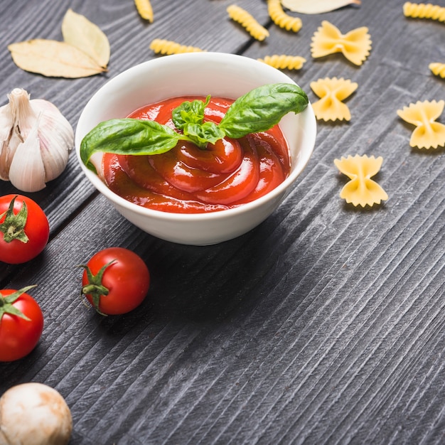 Prepared fresh tomato sauce with basil leaf on table