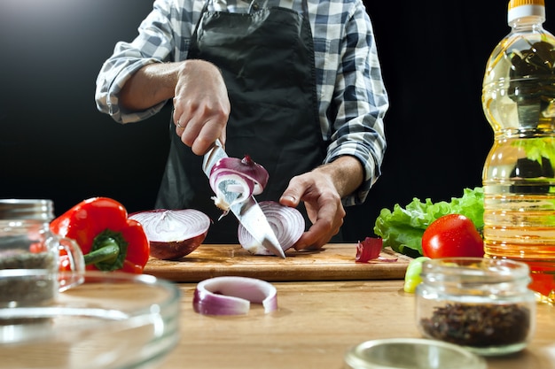 Preparing salad. Female chef cutting fresh vegetables.