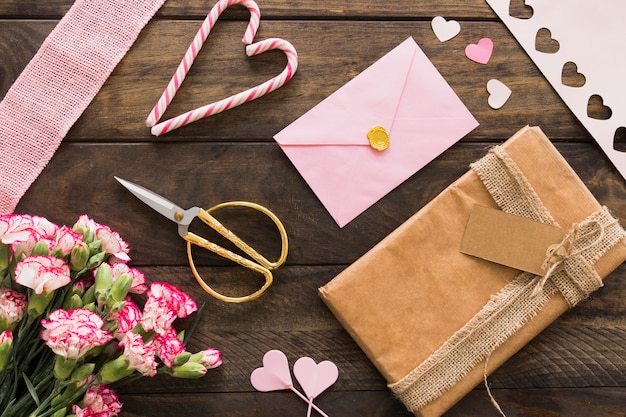 Present box between flowers, envelope and candy canes