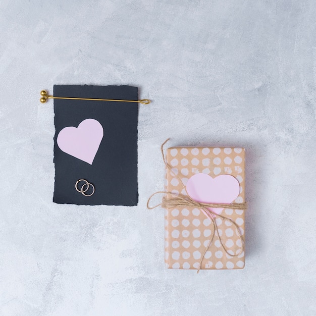 Free Photo present box near black paper and symbols of heart