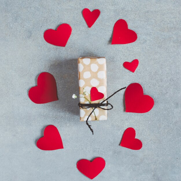 Present box between set of paper hearts 