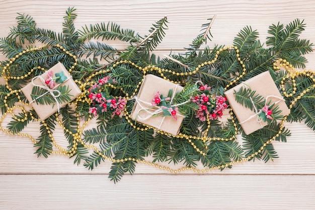 Free photo present boxes on ornamented fir branches and beads