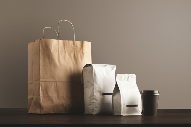 Presentation of retailer package set. craft paper bag, big pouch, small container and take away glass with cap.