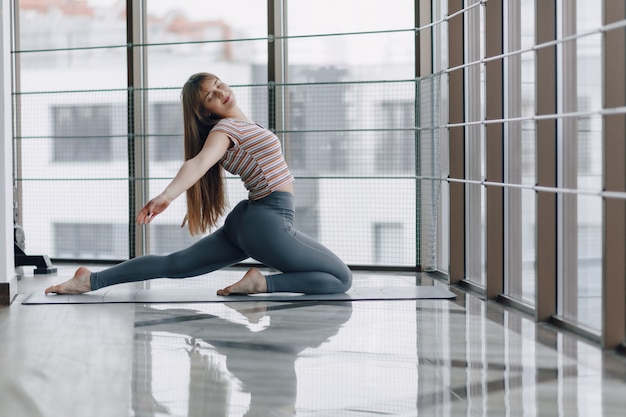 Pretty attractive girl doing yoga in a bright room