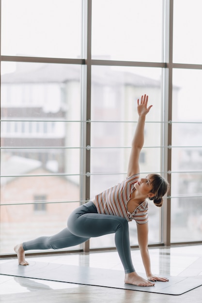 Pretty attractive girl doing yoga in a bright room