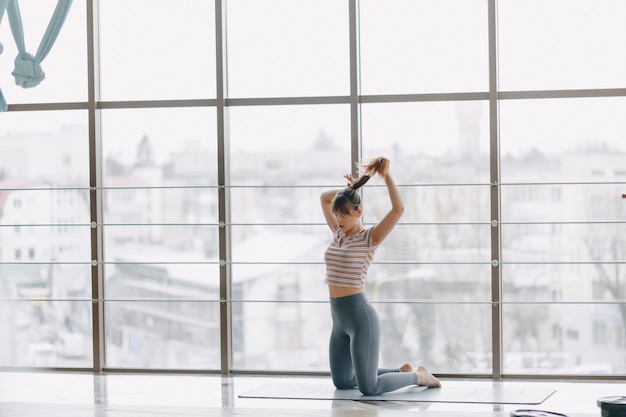 Pretty attractive girl doing yoga in a bright room