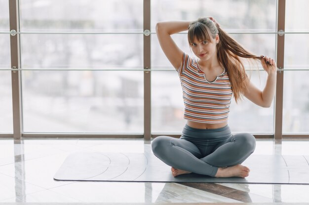 Pretty attractive girl doing yoga in a bright room