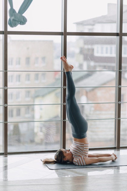 Pretty attractive girl doing yoga in a bright room