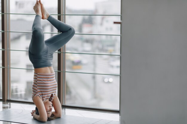 Pretty attractive girl doing yoga in a bright room