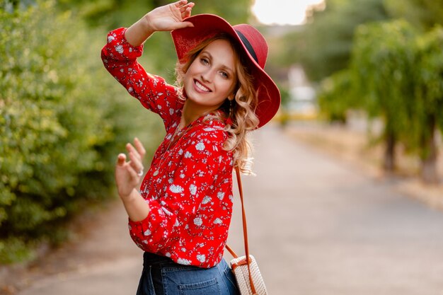 Pretty attractive stylish blond smiling woman in straw red hat and blouse summer fashion outfit