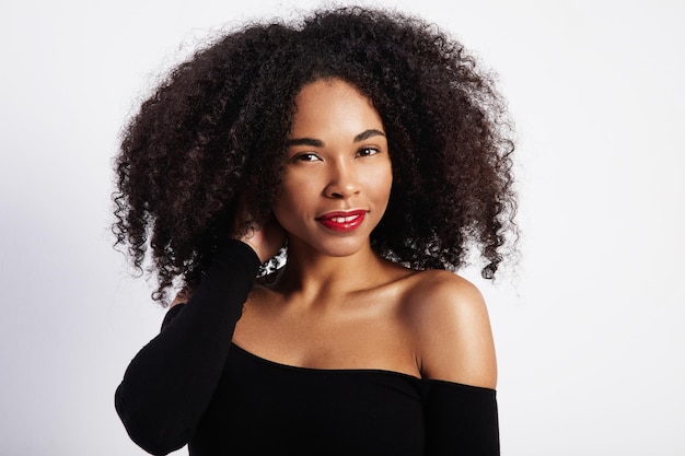 Free photo pretty black woman touches her curly hair