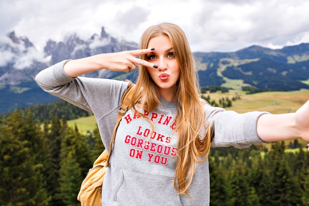 Free Photo pretty blonde traveler woman having fun at mountains.