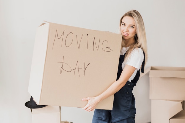 Pretty blonde woman holding carton box