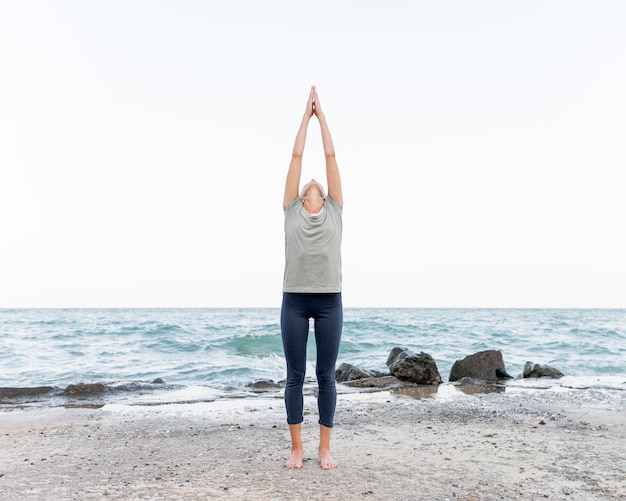 Free photo pretty blonde woman practicing yoga outdoors