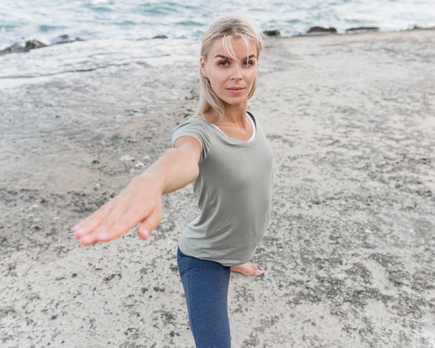 Pretty blonde woman practicing yoga outdoors