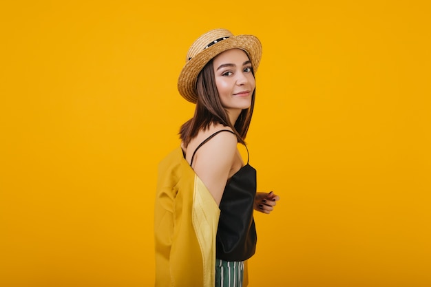 pretty brunette girl wears straw hat. Indoor portrait of magnificent lady isolated.