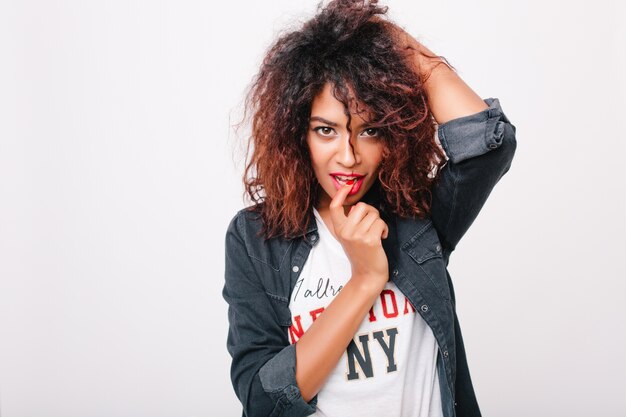 Pretty brunette lady with bright make-up having fun. Portrait of fashionable black girl in denim clothes sensually posing.