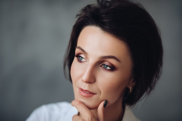 Pretty Caucasian female model with short hair isolated on grey studio background