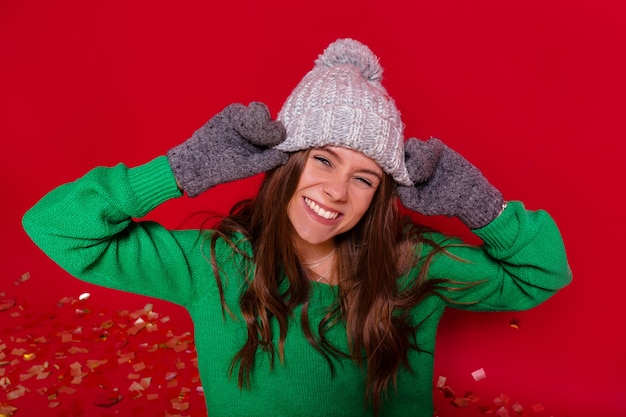 Free Photo pretty charming young woman on red wall in winter outfit