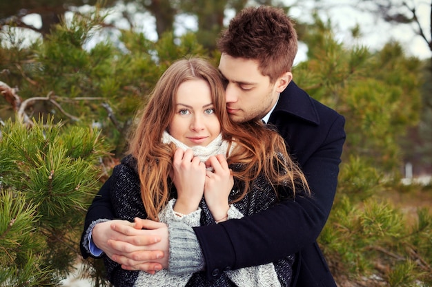 Pretty couple hugging and flirting on a winter day