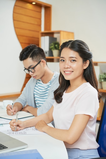 Pretty ethnic woman in office with colleague