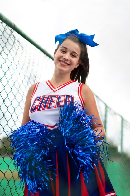 Pretty female cheerleader in cute uniform