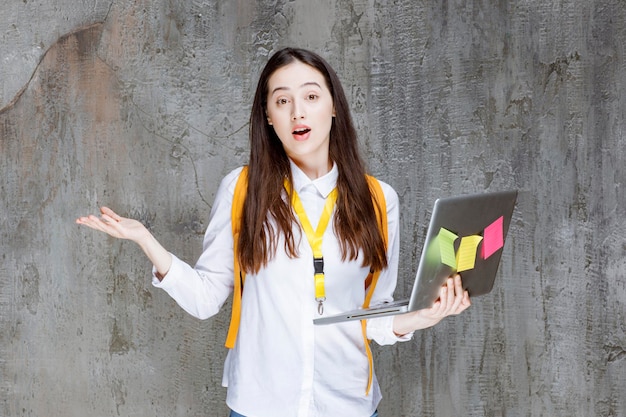 Free photo pretty female student with yellow backpack laptop standing and posing. high quality photo