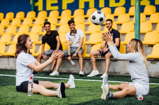 Free photo pretty football player man stretching leg muscle preparing for match in stadium