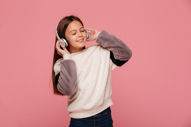 Pretty girl enjoying music in headphones isolated