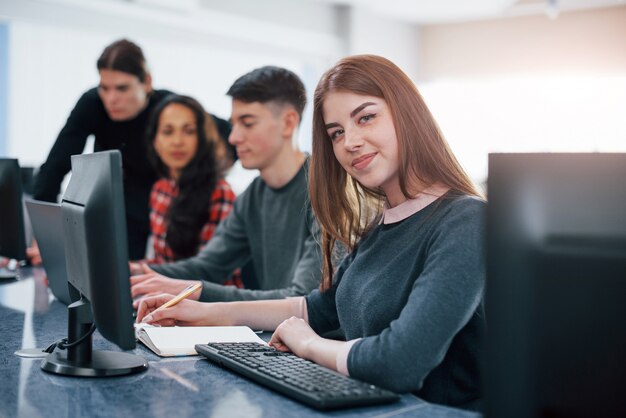 Pretty girl. Group of young people in casual clothes working in the modern office